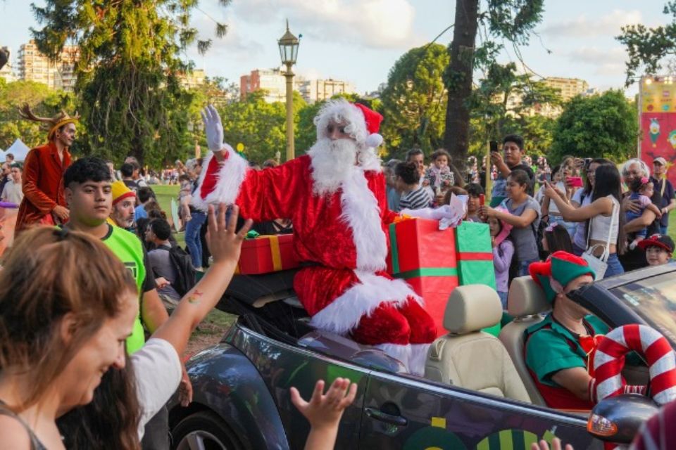 Papá Noel en una carroza saludando a la gente