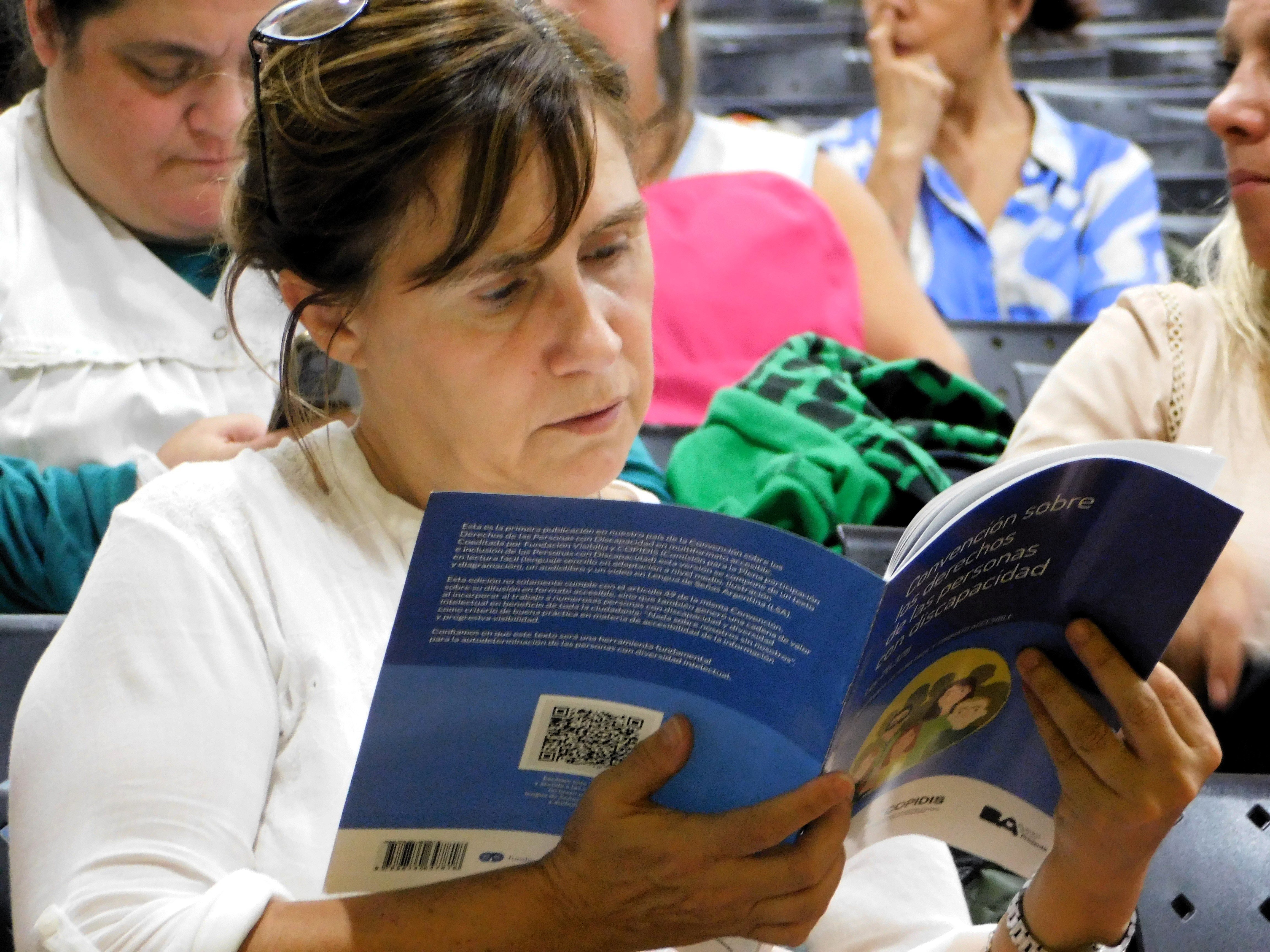 Fotografia de un docente leyendo la convencion internacional de derechos de personas con discapacidad en lectura facil