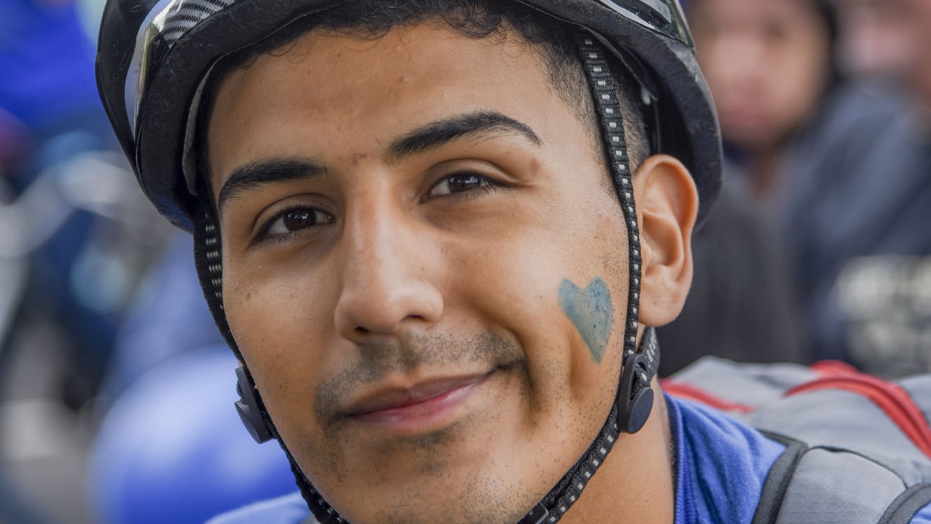 fotografia de un hombre con casco y corazon azul dibujado en la mejilla izquierda