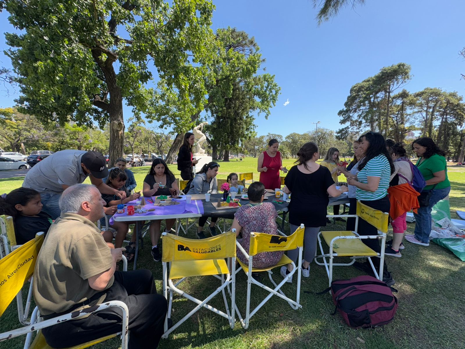 Imagen tomada del grupo de personas que participaron del evento a la salida de la estación saluidable. Estan todos sentados frente a una mesa interactuandol. La atmofera parece ser distendida y alegre