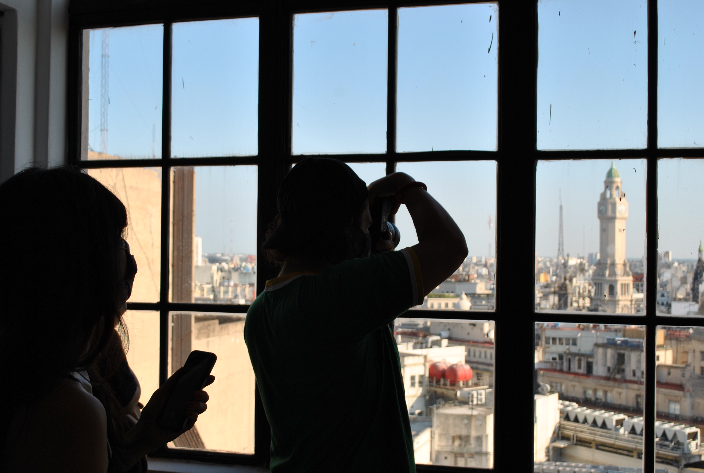 Personas mirando cupulas de edificios desde una ventana