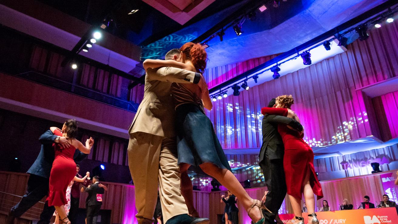 Varias parejas bailando tango de pista siendo evaluadas por el jurado