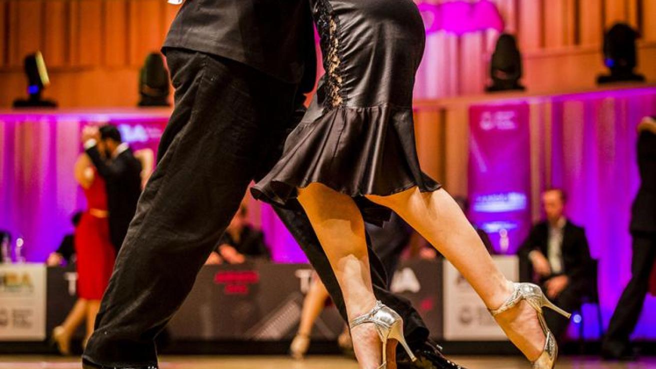Plano cerrado de las piernas de dos personas bailando tango escenario