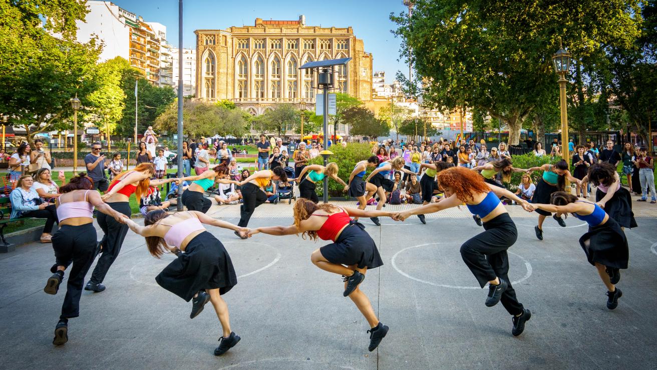 Grupo de personas bailando en ronda en Plaza Mitre