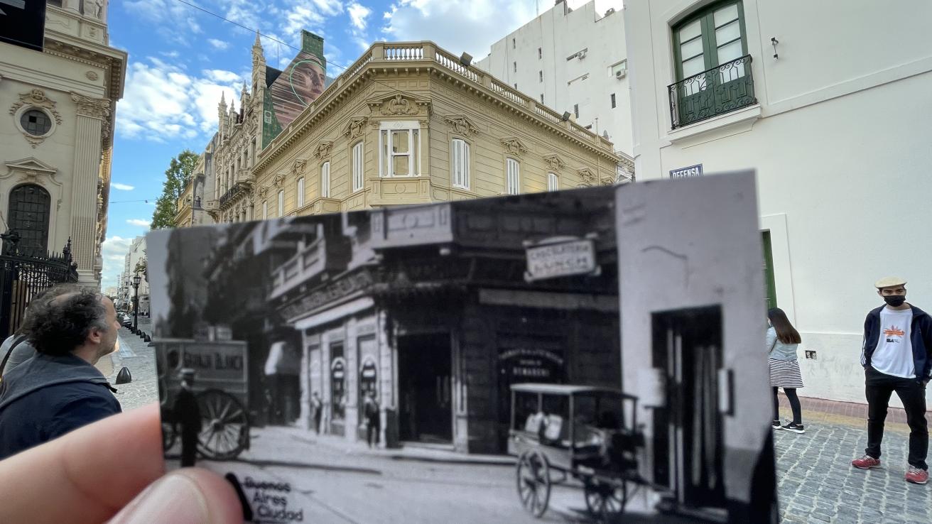 Mano con foto antigua frente a la fachada actual de la calle