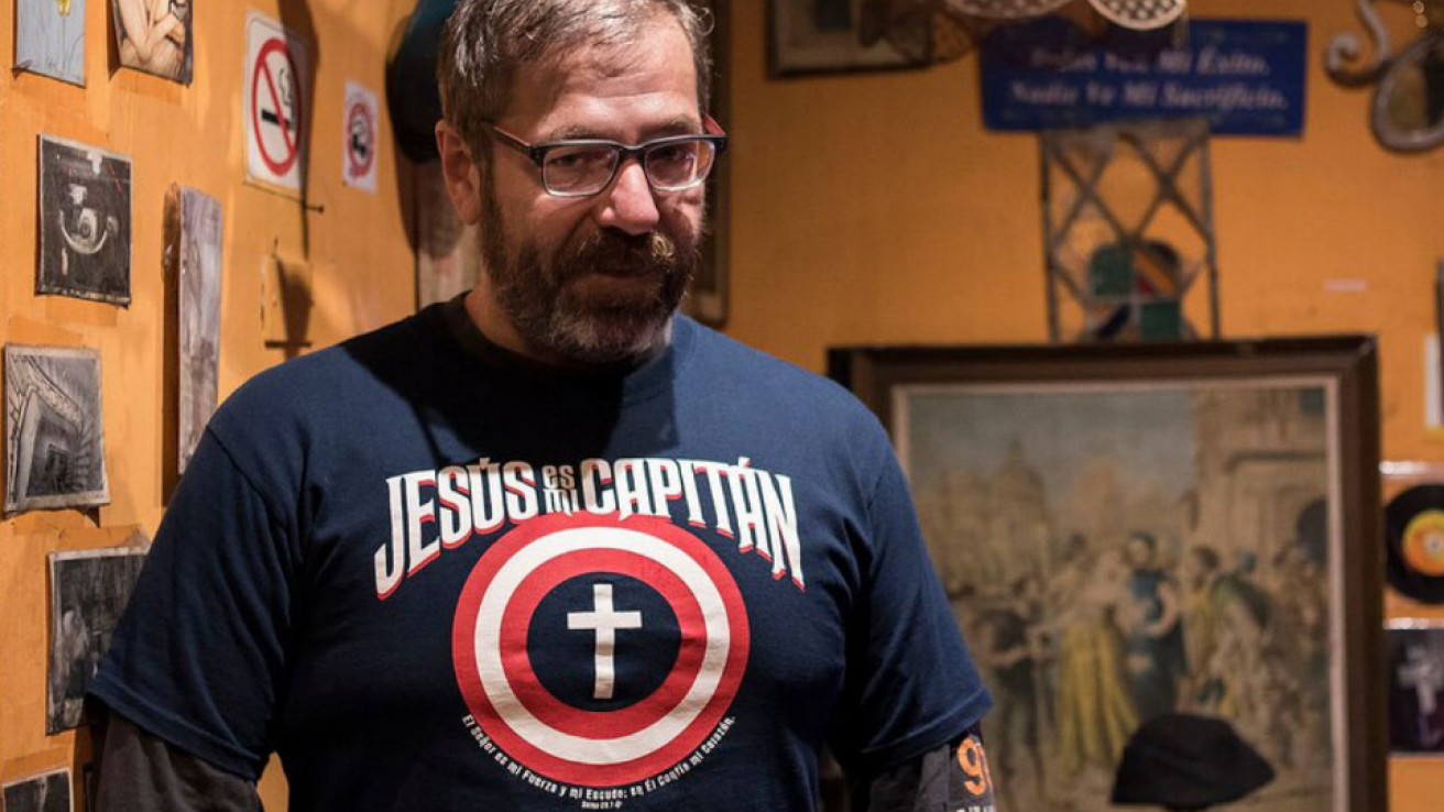 Hombre y cuadros de fondo