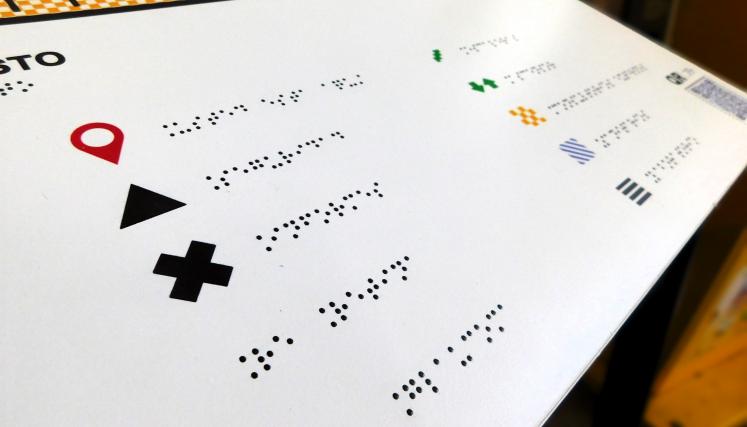 Fotografía donde se observa braille escrito en el tablero del plano