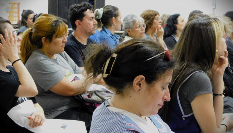 Imagen tomada en lateral en la que destaca a los asistentes, sentados, en concentración a la exposición 