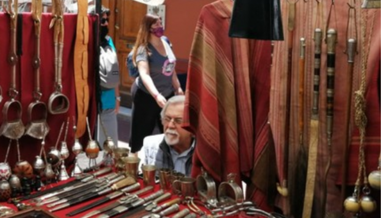 Hombre vendiendo artículos de cuero y cuchillos en la feria de San Telmo