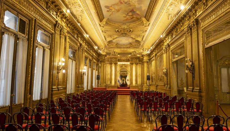 Salón antiguo dorado con sillas tapizadas rojas