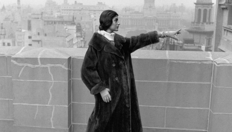 Mujer con abrigo de piel en terraza, de fondo el Congreso