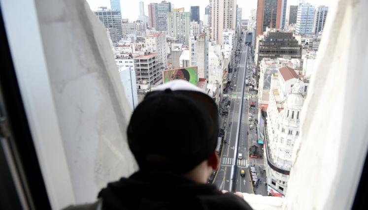 Persona mirando por una de las ventanas del Obelisco, la vista en altura de la Ciudad