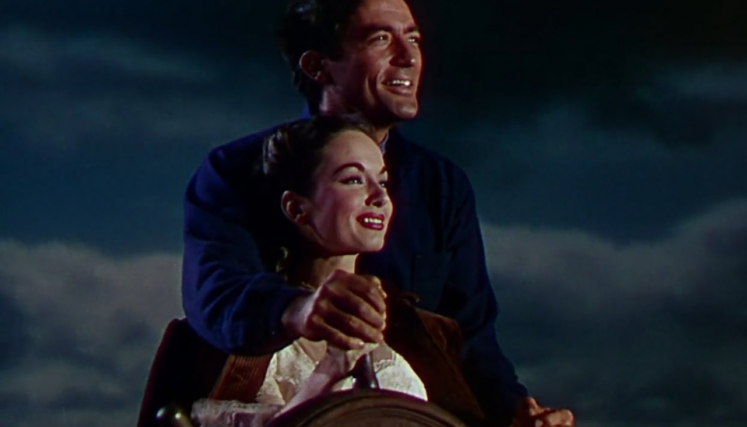 Mujer y hombre manejando un timón de un barco