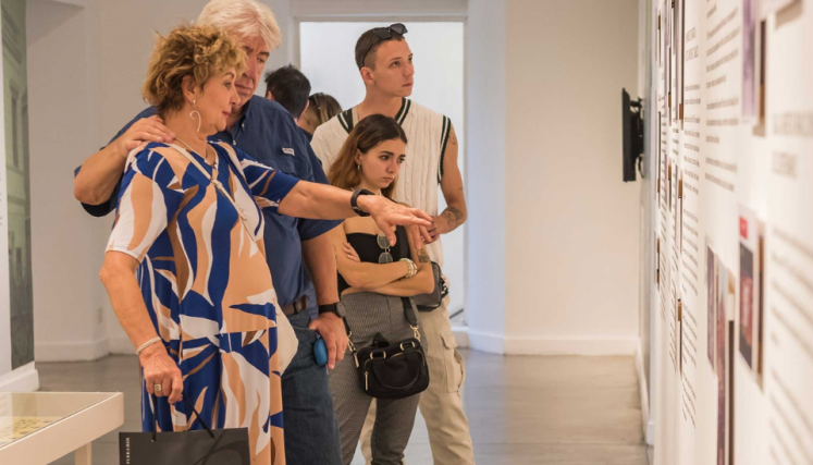 Personas leyendo un texto en una exposición