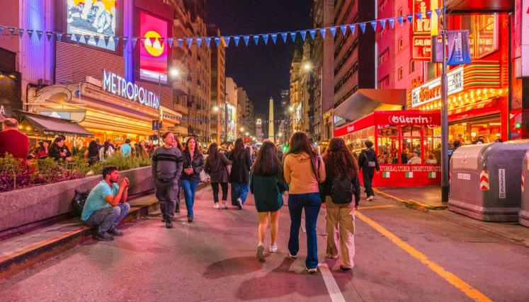 Personas caminando por calle Corrientes de noche