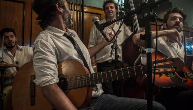 Cuatro hombres con instrumentos musicales